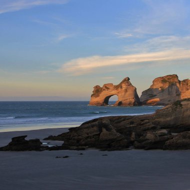 Whariki Sahili 'nde altın akşam ışığında kemer şeklinde kaya oluşumu..