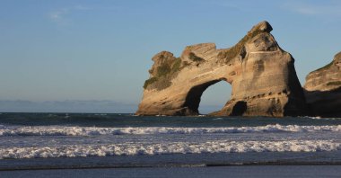 Unique rock formation at Wharariki Beach, New Zealand. clipart