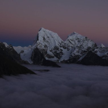 Cholatse and Taboche at sunset, sea of fog, view from Gokyo Ri, Nepal. clipart