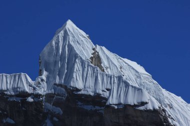 Blue sky over the pointed peak Lobuche East, Nepal. clipart