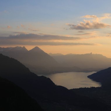 Thun Gölü ve Niesen Dağı üzerinde altın akşam gökyüzü, İsviçre.