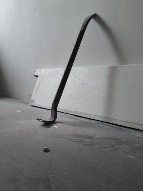 Kullanılmış bir levyeyi kapat. Evdeki tamirat için hurda kullanılıyor. Ev onarımı sırasında zemin koruma altına alınıyor. Duvara dayanmış demir parçaları..