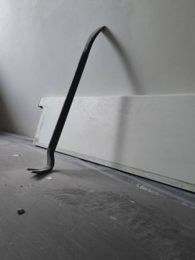 Kullanılmış bir levyeyi kapat. Evdeki tamirat için hurda kullanılıyor. Ev onarımı sırasında zemin koruma altına alınıyor. Duvara dayanmış demir parçaları..