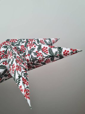Şenlik desenli bir Noel kâğıdı yıldızı. Tavana karşı şenlikli bir arka plan. Aralık tatilinde kullanılan soyut bir özgeçmiş.