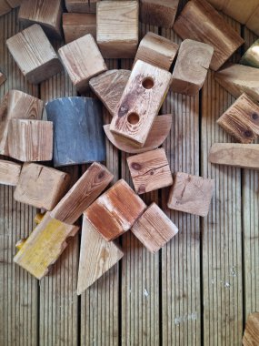 Ahşap küplü bir arka plan. Dağınık ahşap figürler. Çocuklar için eğitici oyunlar için tahta oyuncaklar.