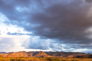 Namibya dağının tepesinde kara bulutlar toplanıyor.