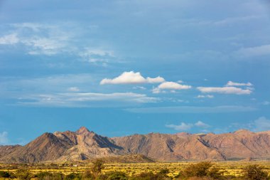 Kayalık Namibya dağının tepesinde mavi ve beyaz bulutlar