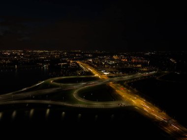 Gece A10 karayolu trafiği. Hollanda 'nın Amsterdam Ijburg şehrinde yol üzerindeki hareketli dinamik trafik ışığı altındaki karayolu altyapısı. Hava aracı gece fotoğrafçılığı.