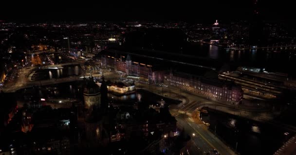 阿姆斯特丹市中心的天际线由夜间空中无人机俯瞰 阿姆斯特丹中心 Prins Hendrikkade 公共交通 夜间交通 城市明亮的灯光 — 图库视频影像