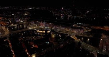 Amsterdam şehir merkezinin gece boyunca gökyüzü görüntüsü. Amsterdam Centraal, Lj, Prins Hendrikkade, toplu taşıma, gece trafiği. Parlak ışıklar kentsel