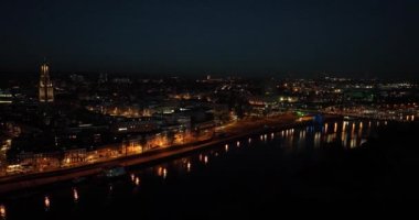 Geceleri Hollanda 'daki Arnhem şehrinde hava aracı. Şehir merkezi, Ren nehri ve kilise, Eusebiuskerk, John Frost köprüsü, ufuk çizgisi ve altyapı, şehir merkezi. Gece karanlık..
