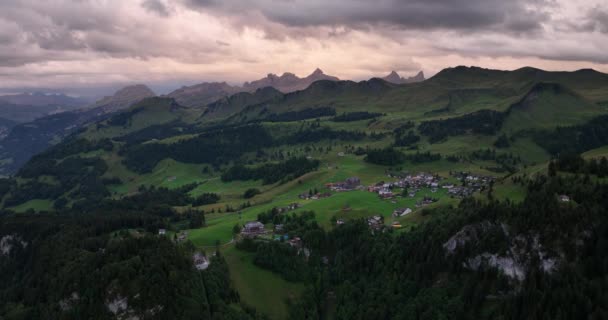 夕暮れ時のスイスのアルプス日没時の美しい赤い空 スキーやストゥースのレクリエーションリゾート山の村 空中ドローンのオーバーヘッドビュー — ストック動画