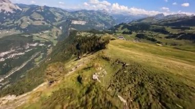 FPV, İsviçre 'deki yeşil bir dağın üzerinde serbest stil ve sinematik dron uçuşu..