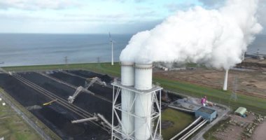 Bir kömür ve biyokütle ateşleme santralinin bacasında yakın uçuş..