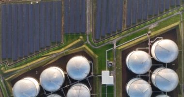 Sürdürülebilir enerji ve fosil enerji yan yana. Güneş panelleri petrokimyasal sıvı gaz deposu. İklim değişikliğine karşı sürdürülebilirlik.