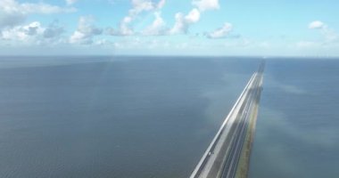 Aerial drone video of the Afsluitdijk in The Netherlands showcasing the 32-kilometer long sea barrier and the picturesque landscapes. Aerial overhead view.