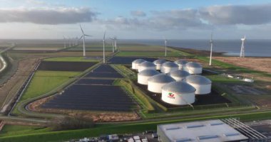 Eemshaven, Het Hogeland, 26th of December 2022, The Netherlands. Incredible aerial footage highlights the striking contrast between the petrochemical silos and wind turbines at Vopak, demonstrating