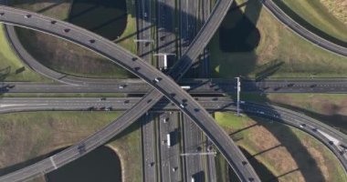 The aerial drone video of Knooppunt Ridderkerk offers a unique perspective of the urban landscape as cars, trucks, and other vehicles navigate the busy intersection