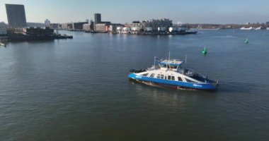 Amsterdam, 13th of February 2023, The Netherlands. View the bustling canals of Amsterdam from a new angle with an aerial drone video of a public transport ferry in motion.