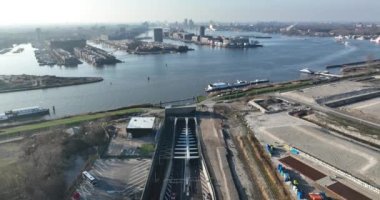 An aerial drone video capturing the dynamic intersection and transport infrastructure of Amsterdam, with the Piet Hein Tunnel and canal connecting the citys bustling districts.