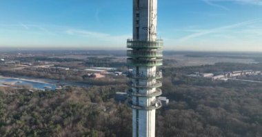 Overhead drone footage reveals the impressive scale of the broadcasting tower at the Mediaworks campus in Hilversum, surrounded by greenery.