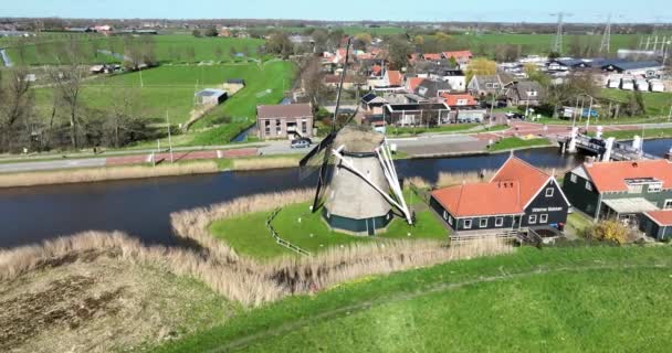 一个迷人的荷兰波兰风车的迷人的无人驾驶镜头 沐浴在温暖的阳光下 让人瞥见宁静的乡村生活 — 图库视频影像