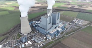 Devasa soğutucu yapıları olan devasa bir enerji santralinin büyüleyici hava manzarası sayısız ev ve işyeri için muazzam miktarda elektrik üretiyor..