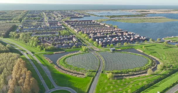 ランドマークと太陽光パネルを備えた大規模太陽光発電所は 再生可能エネルギー クリーンエネルギー グリーンエネルギーを生み出し 都市部の家庭に電力を供給します 空中ドローンビデオ — ストック動画