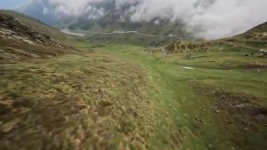 FPV 'nin insansız hava aracı videosu Fransız pireneleriyle dağdaki kayalık bir dağ nehrinin üzerinde yüksek hızda uçuyor..