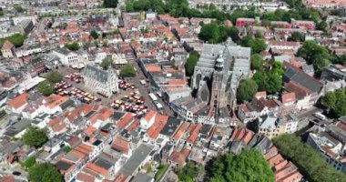 Goudas 'ın ana pazar yeri ve tarihi şehir merkezinin büyüleyici hava perspektifine dalıp canlı pazar atmosferini, Hollanda mimarisini ve manzaralı kanalları sergileyin.