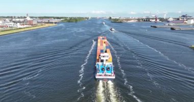 Amsterdam, 21 Haziran 2023, Hollanda. Amsterdam limanında Patraq adlı iç konteynır gemisinin Amsterdam 'a doğru yelken açtığını gösteren bir hava aracı videosu..