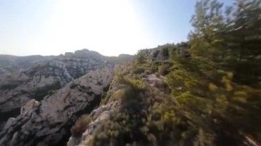 FPV 'nin, Fransa' nın güneyindeki Calanque doğa parkındaki kayalıkların üzerinde sörf videosu..