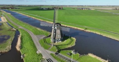 Hollanda geleneklerine göre çim tarlasında tarihi yel değirmeni. Pompalama suyu, hava aracı görüntüsü.