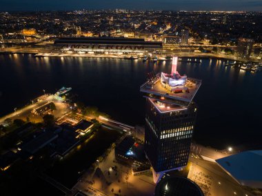 Amsterdam, 19 Ağustos, 2023, Hollanda. Amsterdam gökdeleni geceleyin, Amsterdam Gözcü Kulesi. Hava aracı görünümü.