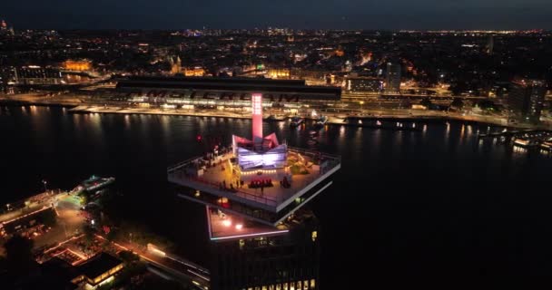 2022年11月19日 アムステルダム オランダ アムステルダムのルックアウトタワーと都市都市の空中ドローンビューは夜に川と都市をスカイラインします — ストック動画