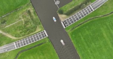 Friesland vilayetindeki su kemerlerinin su altından geçen ve üzerinde yelkenli tekneleri olan insansız hava aracı görüntüleri. Hollanda altyapısı.