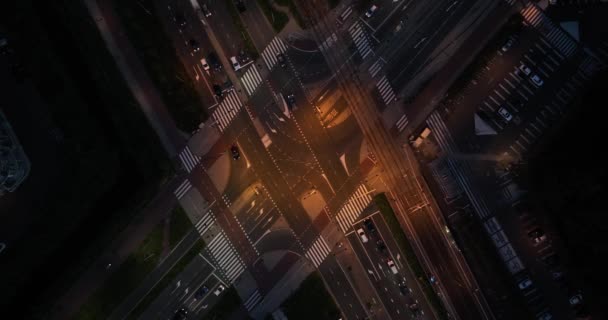 大坝在夜间繁茂的城市景观中 空中无人机图像捕捉了一个复杂的交叉口 卡车和电车汇集在那里 形成了一个运动和光的交响乐 — 图库视频影像