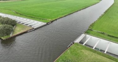 Hollanda, Friesland 'daki bir su kanalı altyapısının havadan aşağı görüntüsü. Suyun altındaki yol.