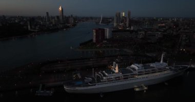 SS Rotterdam 'ın emekli yolcu gemisi artık bir otel olarak hizmet veriyor. Geceleri Rotterdam 'ın silüeti.