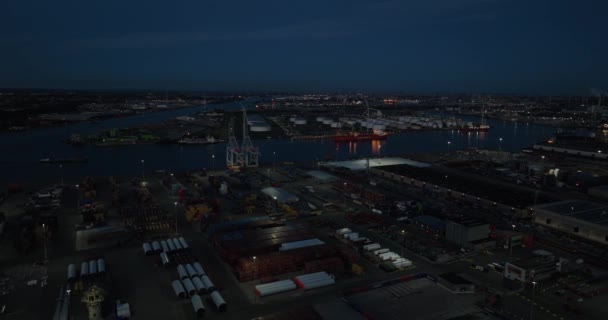 アムステルダムの夜間のドローンビューは 物流会社 海運業界 夕暮れ時に水上輸送に焦点を当てています オランダ — ストック動画