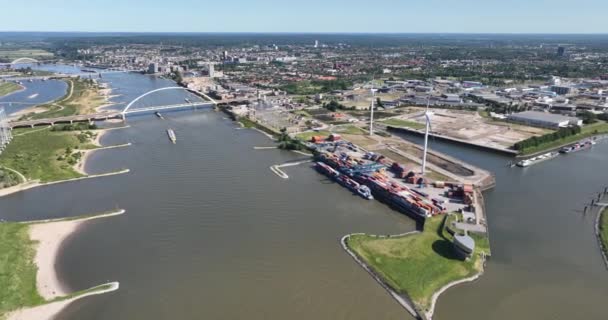 ナイメーゲン市 オランダ デワール川 象徴的な橋と都市の概要の産業側の空中ドローンビュー コンテナポートと産業地帯 — ストック動画