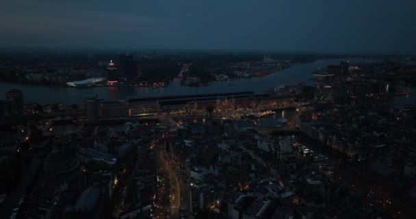 夜间空中无人驾驶飞机俯瞰阿姆斯特丹市中心 Damrak中央车站 Ij河和阿姆斯特丹的高空天际线 — 图库视频影像