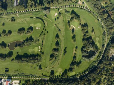 Bir golf sahasının havadan aşağı insansız hava aracı görüntüsü, doğadaki spor aktiviteleri..