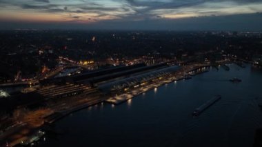 Amsterdam Merkez İstasyonu, Hollanda 'nın başkenti Amsterdam' ın merkezi tren istasyonudur. Amsterdam 'ın ufuk çizgisi, gece şehir manzarası.