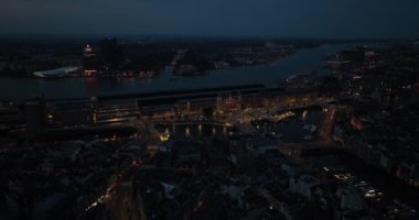Amsterdam Merkez İstasyonu 'nun ve gece şehrin hava aracı görüntüsü. Gece manzarası, şehir merkezi, Amsterdam merkezi ve şehir manzarası..