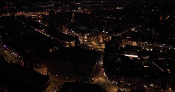 夜間ダム広場の空中ドローンビューとアムステルダムのダウンタウンの都市概要 オランダ — ストック動画