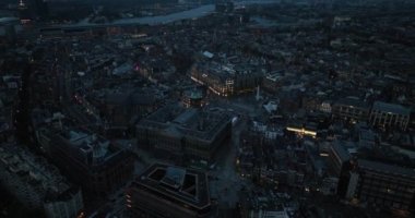 Amsterdam şehir merkezindeki Baraj Meydanı 'nın hava aracı görüntüsünde savaş anıtı ve Kraliyet Sarayı yer alıyor. Gece vakti..