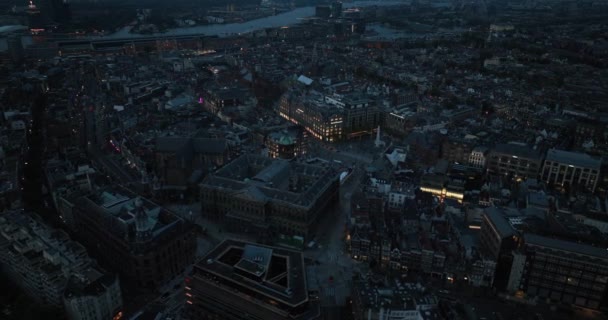アムステルダムの中心街にあるダム広場の空中ドローンビューは 戦争記念碑と王宮をフィーチャーしています ナイトタイム — ストック動画