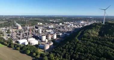 Ağır sanayi bölgesindeki tepenin üzerinde rüzgar türbinleri. Petrokimya endüstrisi. Almanya Ruhr bölgesi.