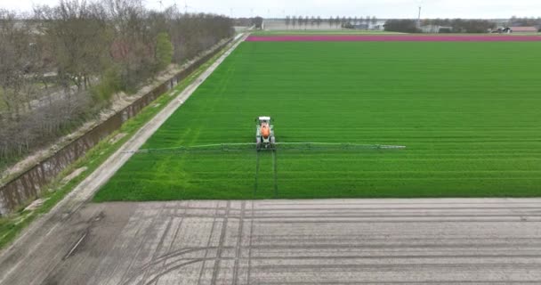 空中无人侦察机看到一辆拖拉机在地上喷水 农业生产者在土地上劳作 春天时间 — 图库视频影像